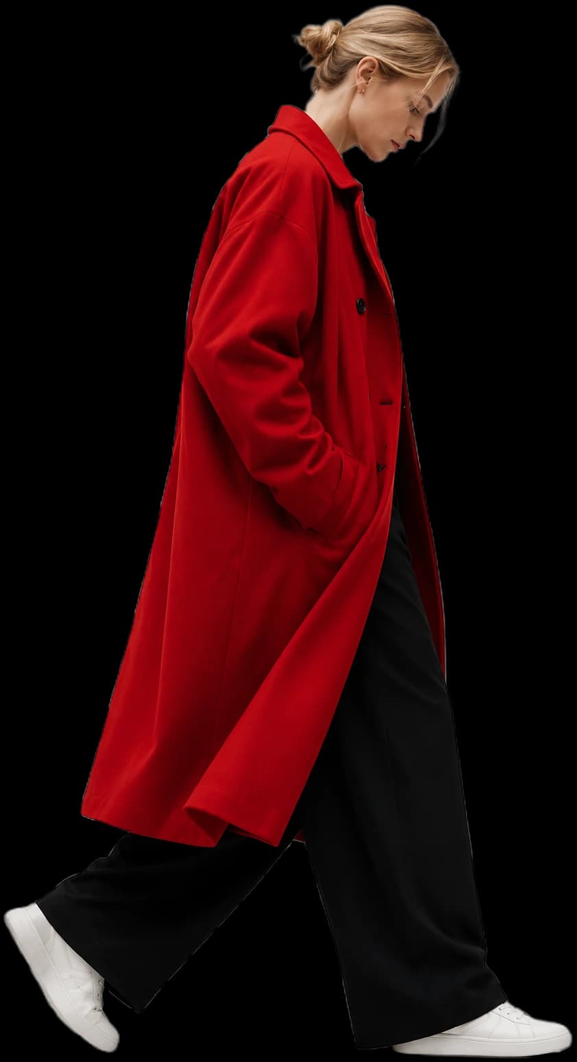 Model walking in an oversized red coat, black wide-leg trousers and white sneakers